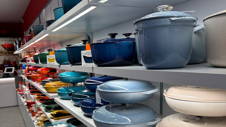 Brightly colored Le Creuset pieces on a store shelf