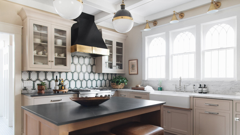 art deco backsplash with beige cabinets and farmhouse sink