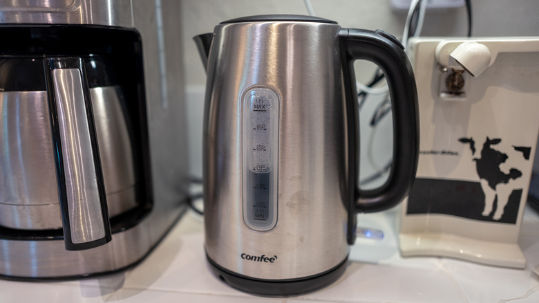 Comfee electric tea kettle alongside other appliances in a domestic kitchen
