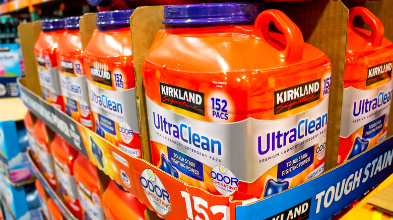 Close up of Kirkland's Ultra Clean laundry detergent pods inside large containers on a Costco shelf.