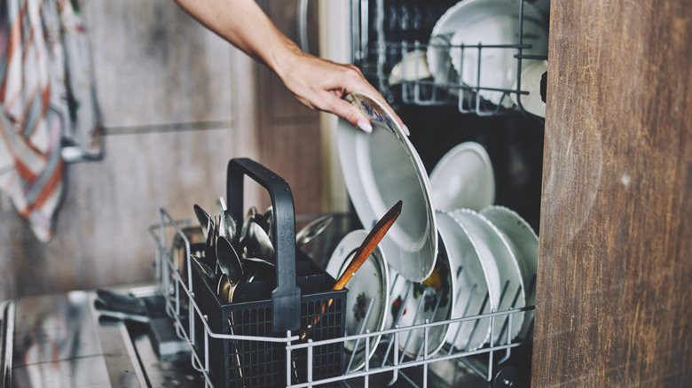 Person putting dirty dishes in a dishwasher