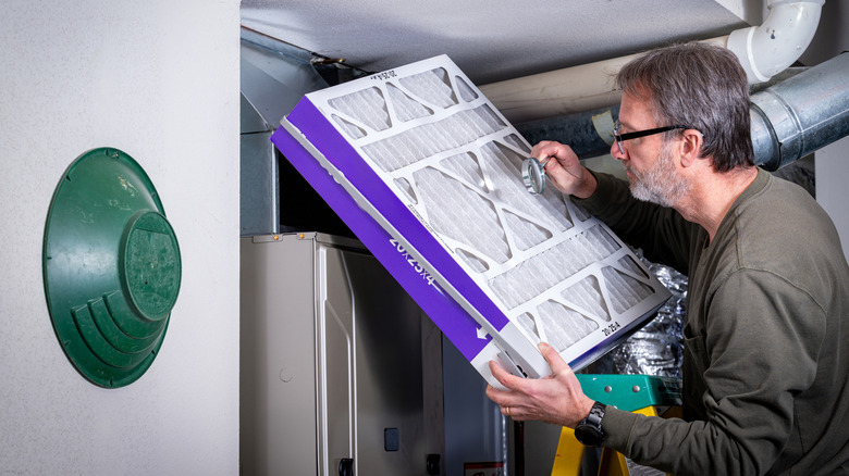 Man inspecting a large furnace filter