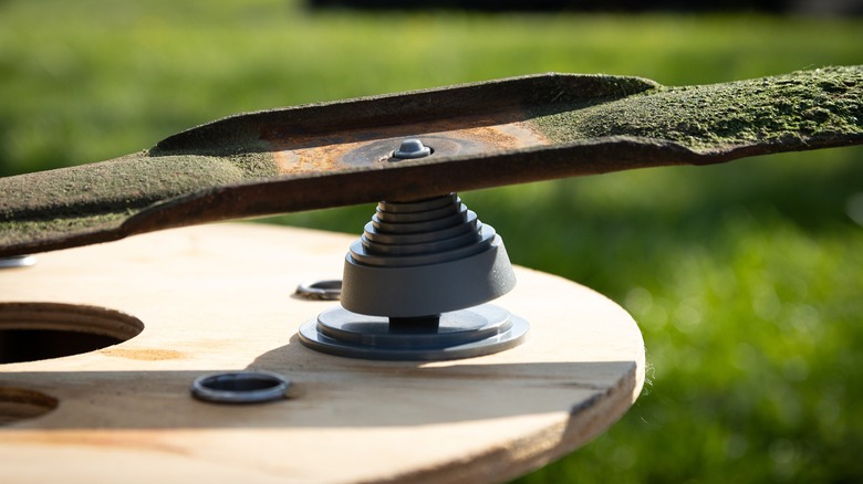 Lawnmower blade on balancing jig looking unbalanced