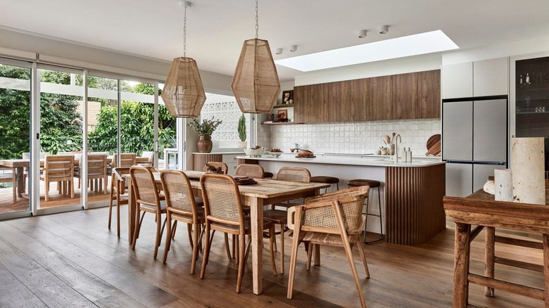 Modern coastal kitchen with woven pendant lighting, chairs, and warm wood accents