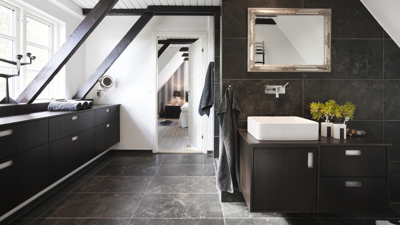 Bathroom with white dark cabinets and dark tile floor