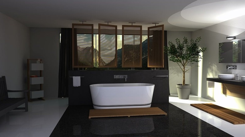 modern bathroom with white tile floor and black tile flooring surrounding freestanding bathtub