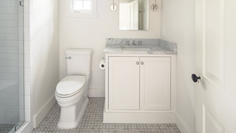 All-white bathroom with small gray tile flooring