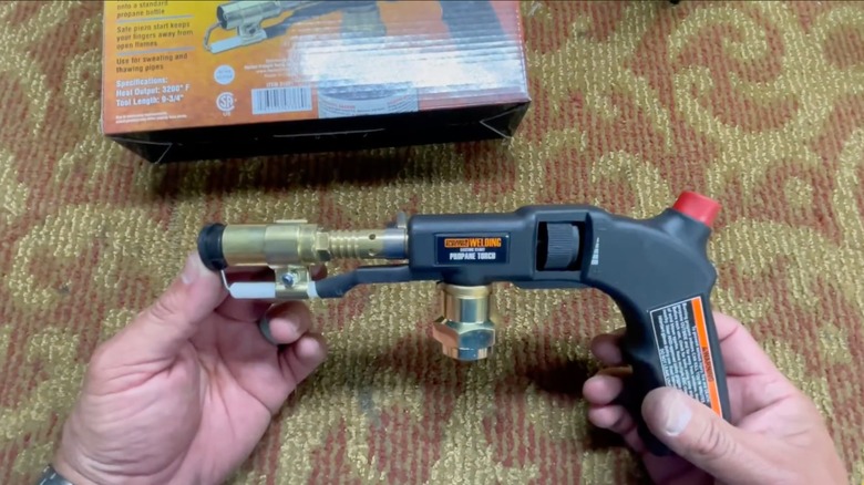 Hands holding Chicago Electric electric start propane torch