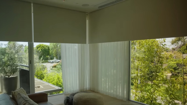 Bedroom with large windows with blackout shades lowered over them