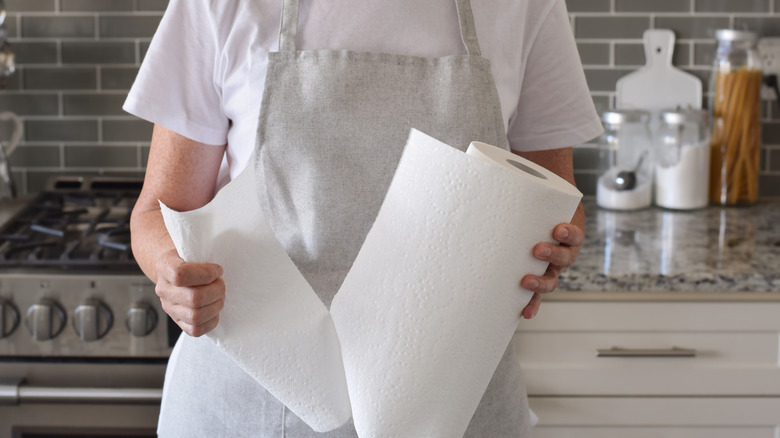 Person tearing off a sheet of white paper towel