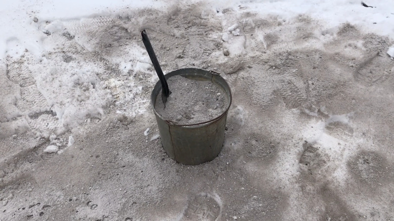 Bucket of wood ash used on icy driveway