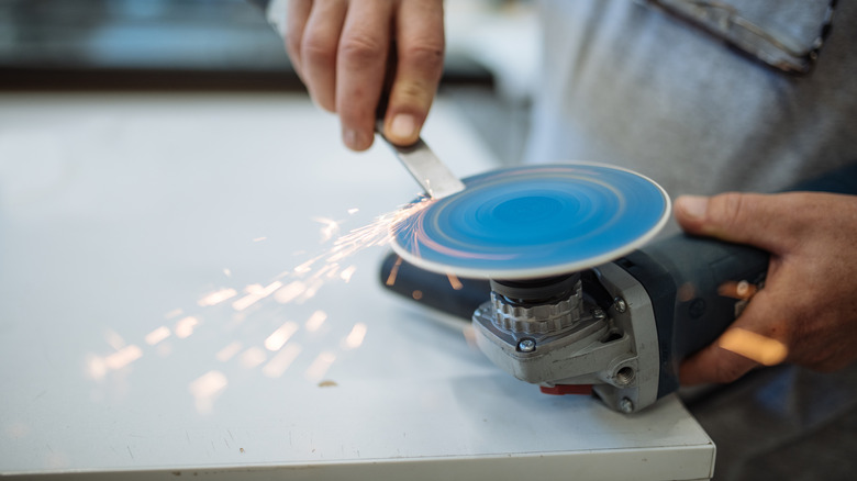 Sharpening a chisel against the flat surface of an angle grinder wheel
