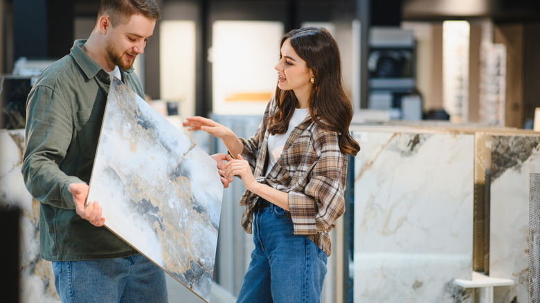 A man and woman are looking at tile options for kitchen backsplash