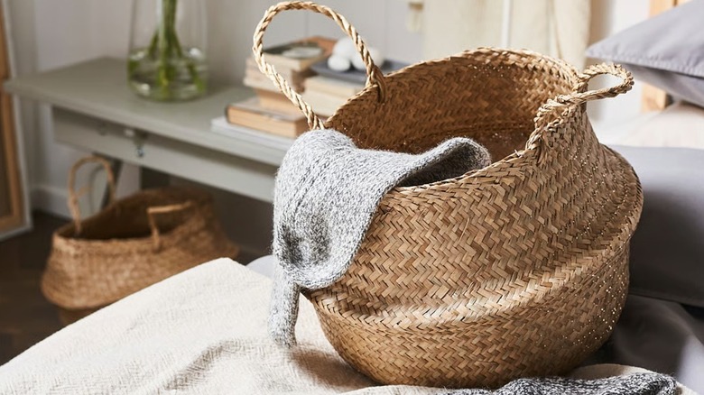 FLÅDIS Basket sitting on bed with sweater inside