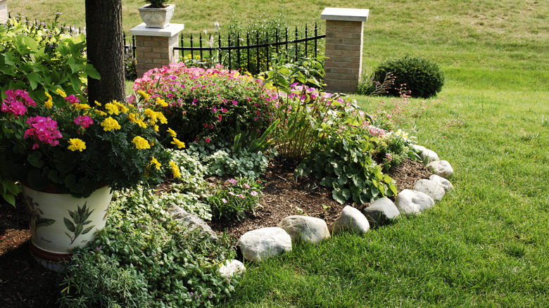 a flower garden with a rock border