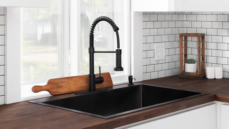 White subway tile backsplash with dark grout in modern kitchen.