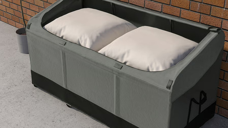 The VÄTTERSÖ Outdoor Storage Box outdoors next to a red brick wall