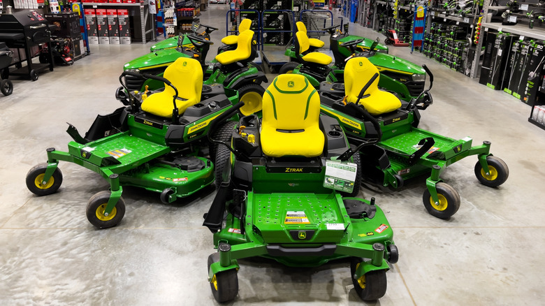 A display of John Deere zero-turn mowers at a retail store