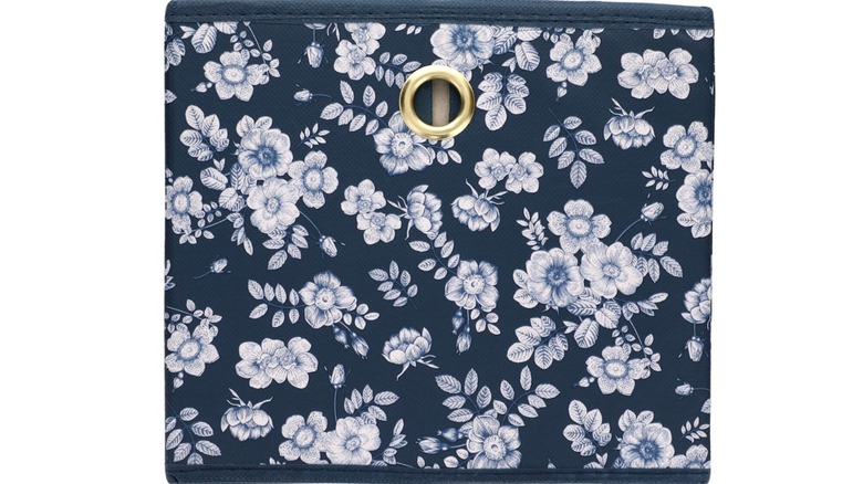 A blue Dollar Tree storage box with white florals