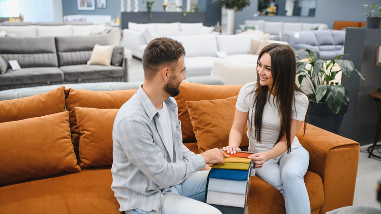 a young couple selecting swatches at a furniture store