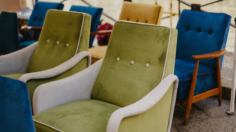 Several mid-century modern armchairs in a tent at a flea market