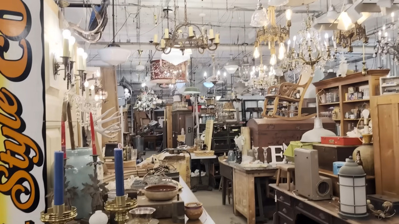 Inside of an architectural salvage shop featuring furniture, light fixtures, and decor