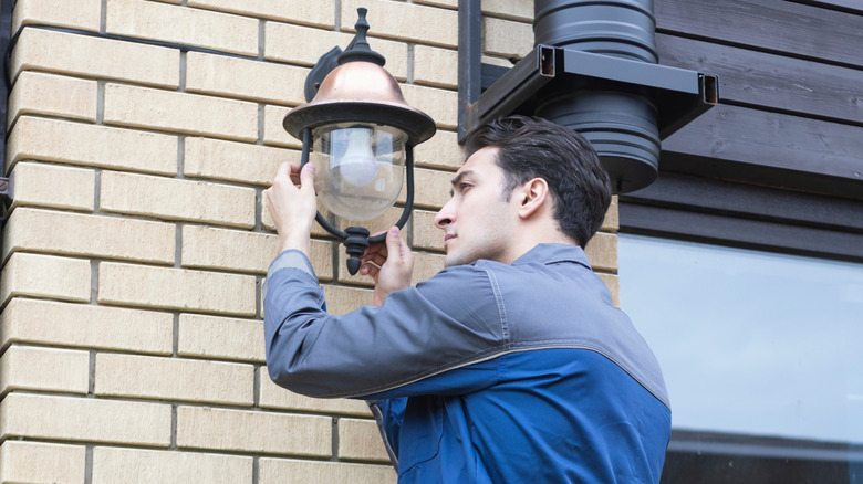 Man changing his outdoor light bulb