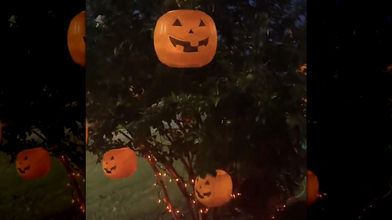 '90s Jack o' lantern Halloween buckets used as tree lanterns in a scene at night