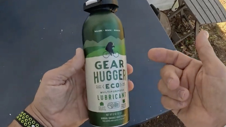 User holding can of Gear Hugger lubricant