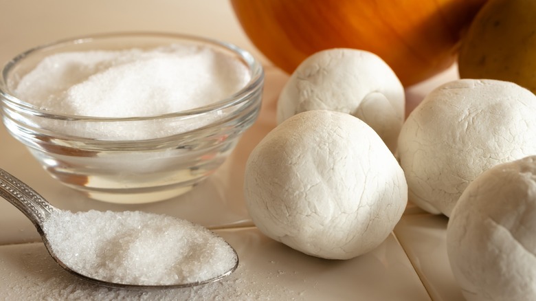 Boric acid in a spoon, a bowl, and molded into balls for bait