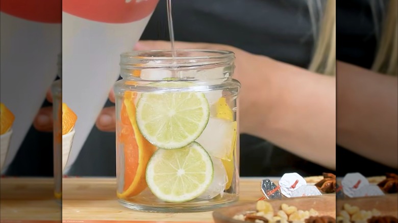 pouring water into jar with fruit slices