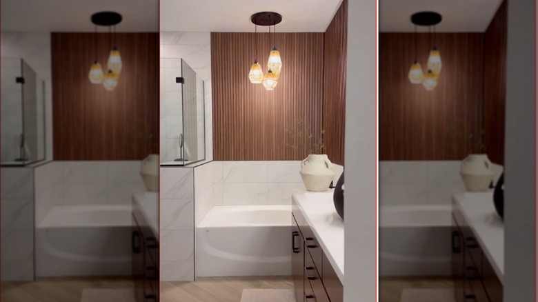 Thin, dark wood paneling covers wall above bathtub.