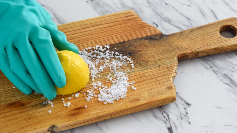 cleaning cutting board with lemon and salt