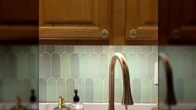 Pastel scalloped backsplash under oak cupboards