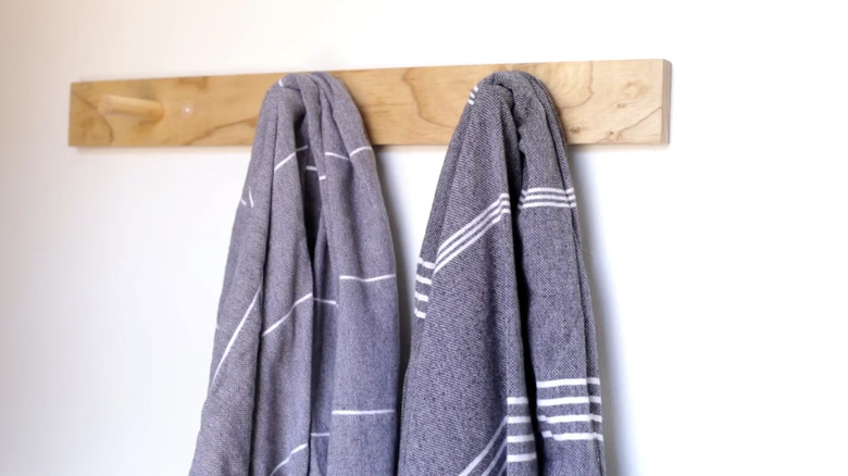A peg rail with two towels hanging from it