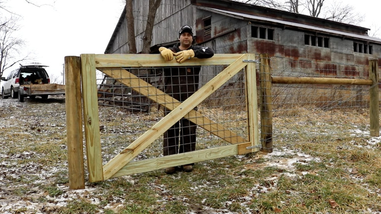 Man standing next to newly built gate