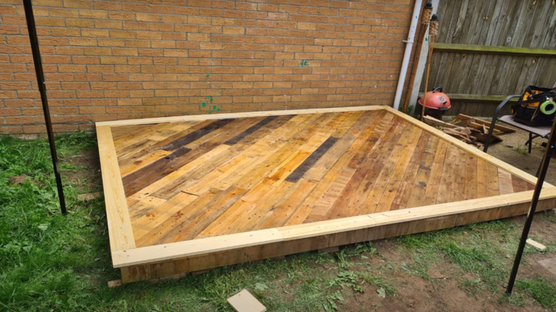 finished pallet patio in backyard as a screenshot from YouTube