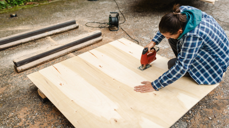 Person cutting thin plywood with a jigsaw