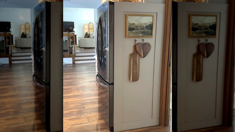 DIY faux-built-in fridge panel made by painting the sides of the appliance and adding magnetic trim