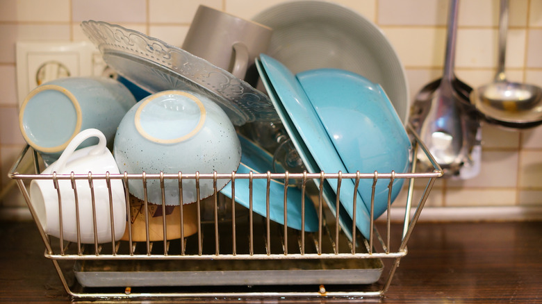 A bulky wire dish rack full of dishes