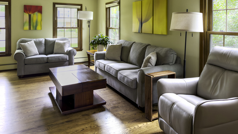 Modern living room with gray furniture and light green walls.