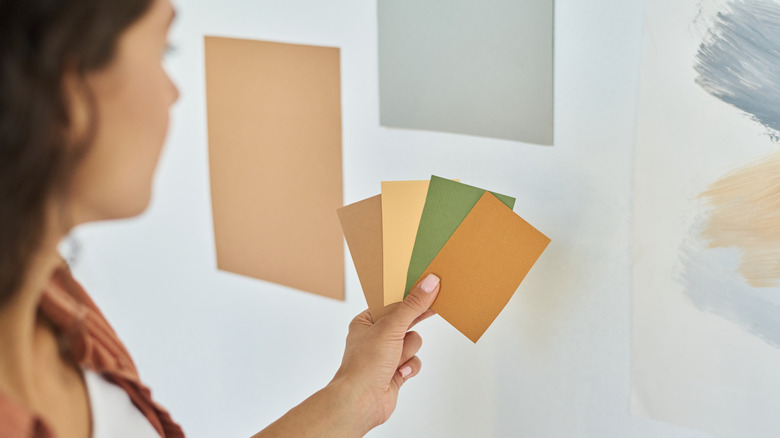 A woman looking at different colored paint swatches