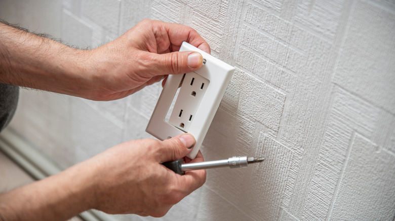 Person installing duplex receptacle