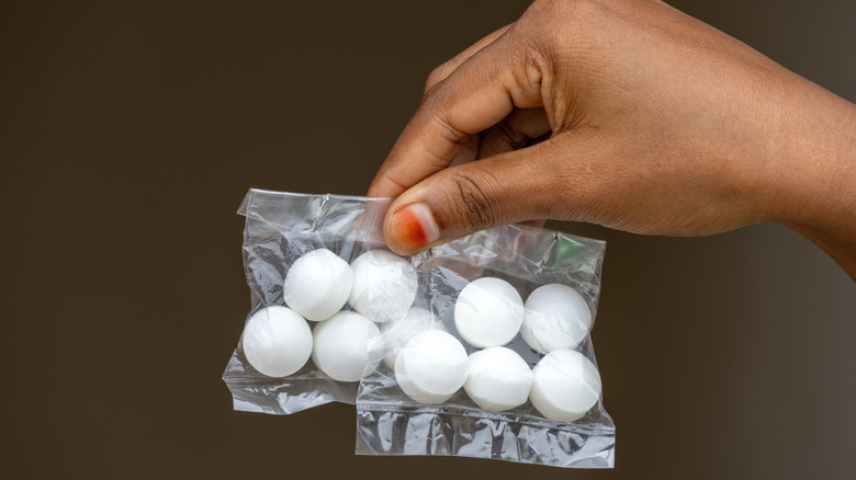 Hand holding bags of mothballs