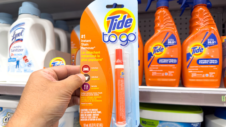A view of a hand holding a package of Tide To Go pen, on display at a local retail store