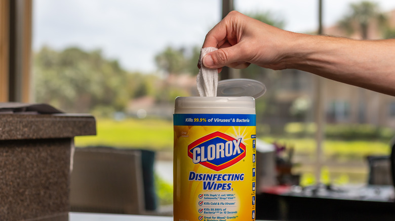 A person reaching for a Clorox disinfecting wipe to clean counters.