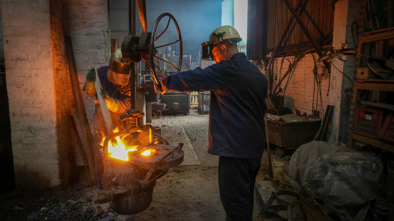 Foundrymen working with molten iron in a factory