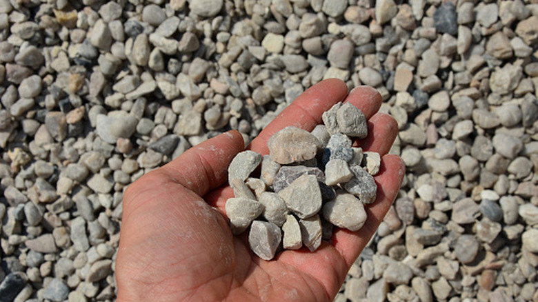 A hand holding gravel of various colors