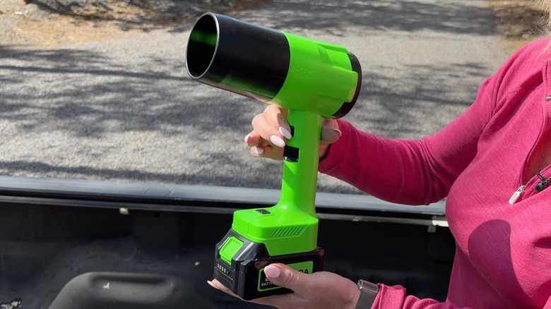 Woman holding Yoovl Cordless Handheld Leaf Blower outdoors