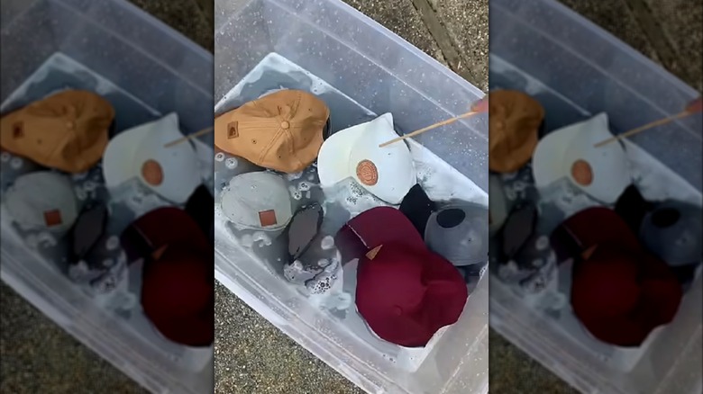 Container of baseball hats being laundry stripped